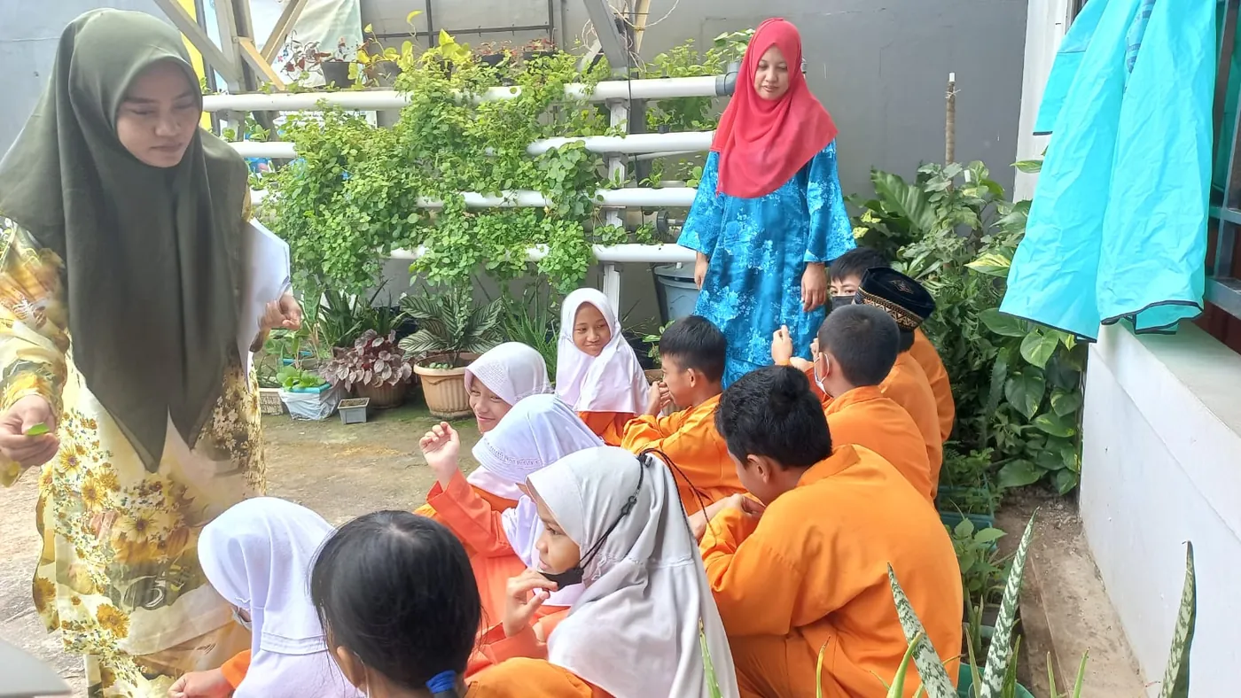 Siswa duduk bersama di taman sekolah