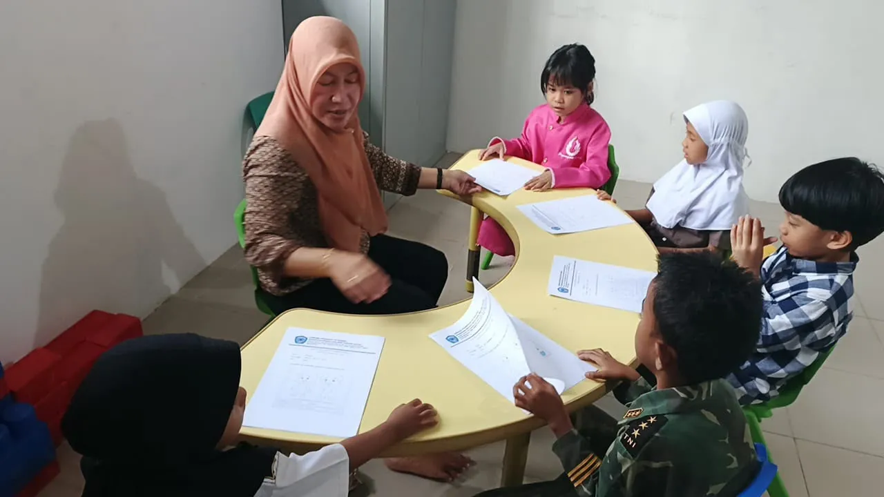 Guru mendampingi siswa belajar di meja kelompok