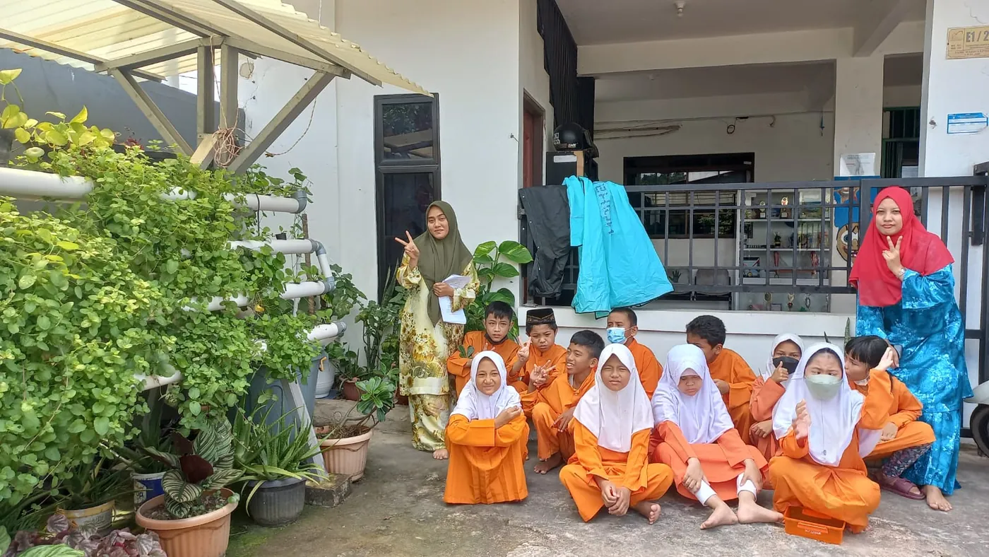 Siswa dan guru SLB Anak Brilliant berfoto di taman sekolah
