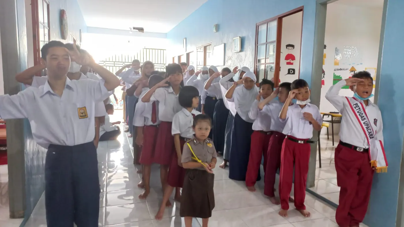 Siswa memberi hormat saat upacara di lorong sekolah